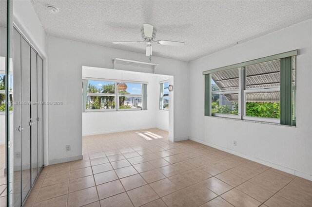 401 S Golf Blvd Unit 270, Pompano Beach, FL 33064 - spare room with healthy amount of natural light, a ceiling fan, tile patterned floors, and a textured ceiling