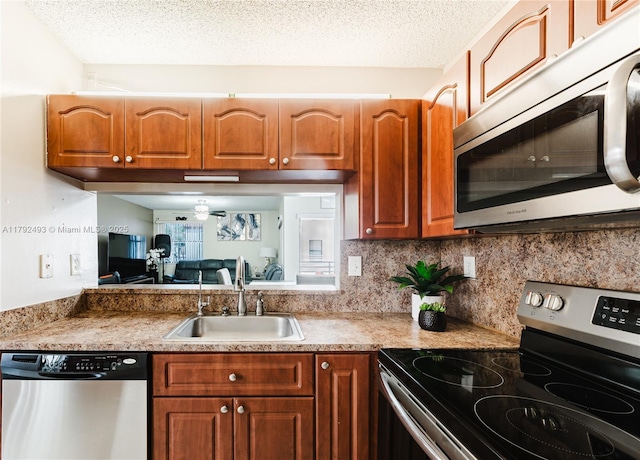 1100 N Hiatus Rd Unit 1100, Pembroke Pines, FL 33026 - kitchen with a sink, stainless steel appliances, brown cabinets, and a textured ceiling