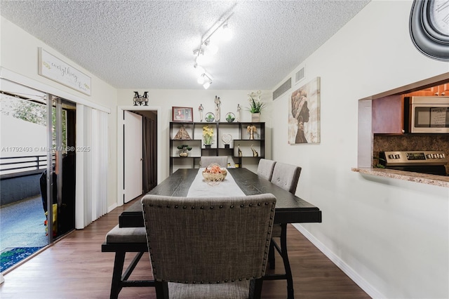 1100 N Hiatus Rd Unit 1100, Pembroke Pines, FL 33026 - dining room featuring dark wood-style flooring, a textured ceiling, visible vents, and baseboards