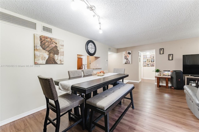 1100 N Hiatus Rd Unit 1100, Pembroke Pines, FL 33026 - dining area featuring baseboards, a textured ceiling, visible vents, and wood finished floors