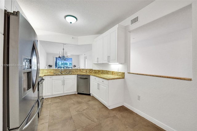 7715 Southampton Ter Unit 110, Tamarac, FL 33321 - kitchen with light stone countertops, a sink, a chandelier, stainless steel appliances, and white cabinetry
