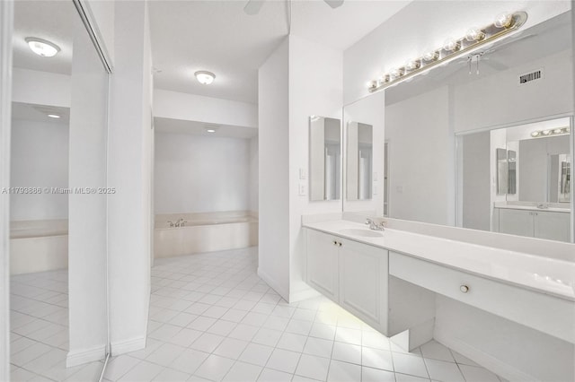 7715 Southampton Ter Unit 110, Tamarac, FL 33321 - full bath with visible vents, a garden tub, tile patterned flooring, vanity, and baseboards