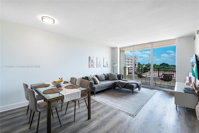 living area featuring a textured ceiling, floor to ceiling windows, and wood finished floors