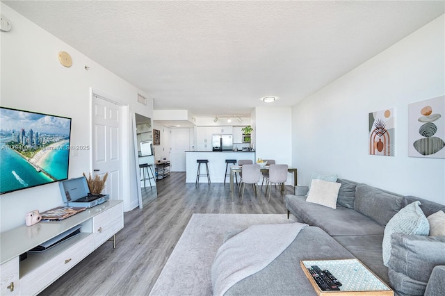 living area featuring light wood finished floors and visible vents