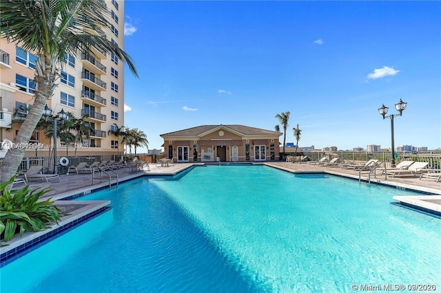 community pool with fence and a patio area