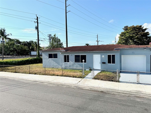 145 NW 2nd St, Dania Beach, FL 33004 - ranch-style house featuring a fenced front yard, an attached garage, a gate, and driveway