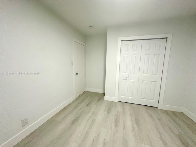 145 NW 2nd St, Dania Beach, FL 33004 - unfurnished bedroom featuring light wood-type flooring, baseboards, and a closet