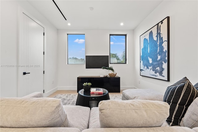 living area with recessed lighting, baseboards, and wood finished floors