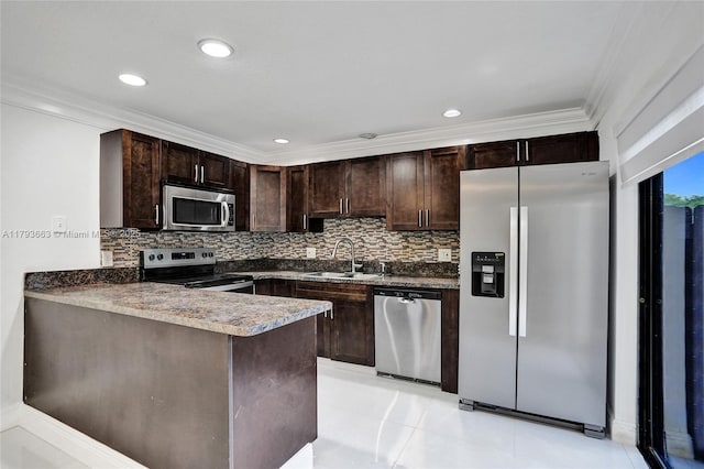 kitchen featuring appliances with stainless steel finishes, a sink, dark brown cabinets, tasteful backsplash, and crown molding