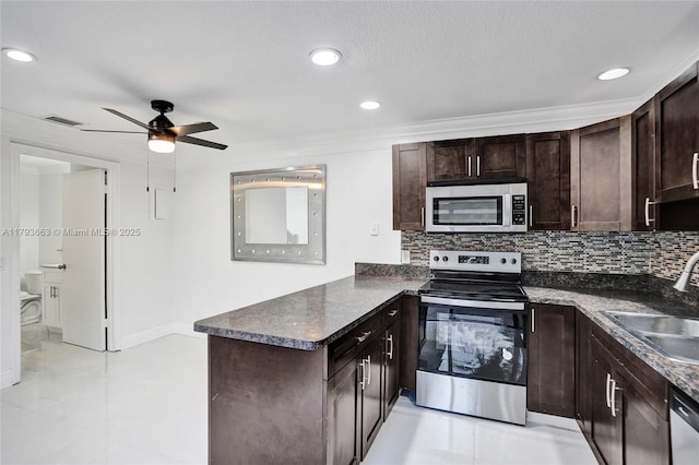 kitchen with stainless steel appliances, a sink, a peninsula, dark brown cabinetry, and ceiling fan