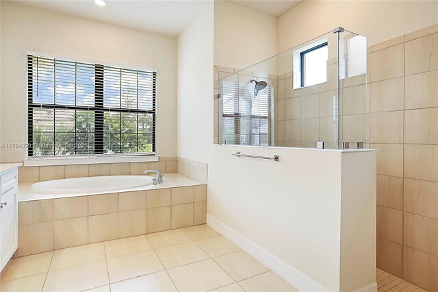 full bath with tile patterned floors, walk in shower, and a garden tub