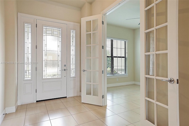 foyer featuring light tile patterned floors, baseboards, and french doors