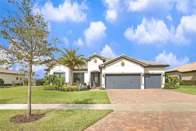 mediterranean / spanish-style home featuring a front yard, decorative driveway, stucco siding, a tiled roof, and an attached garage
