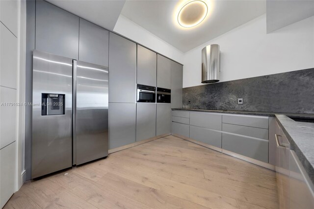 16001 Collins Ave Unit 707, Sunny Isles Beach, FL 33160 - kitchen featuring stainless steel fridge with ice dispenser, gray cabinetry, light wood-type flooring, tasteful backsplash, and modern cabinets