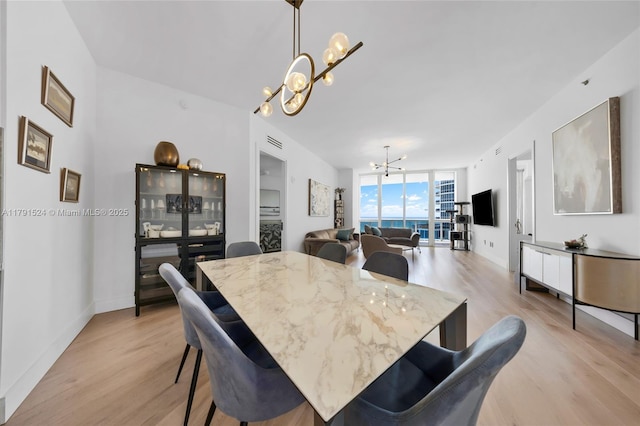 16001 Collins Ave Unit 707, Sunny Isles Beach, FL 33160 - dining room featuring a chandelier, light wood-style floors, expansive windows, and baseboards