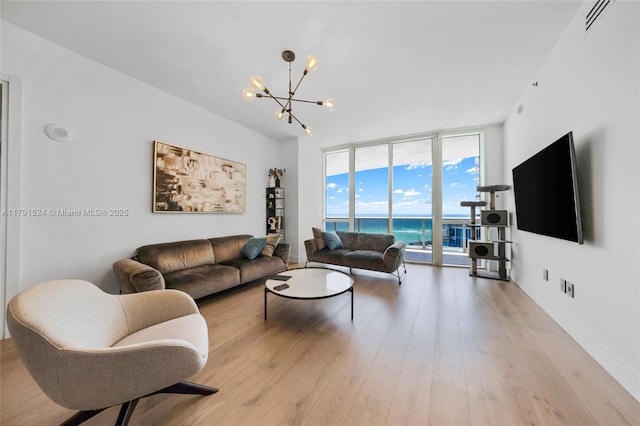 16001 Collins Ave Unit 707, Sunny Isles Beach, FL 33160 - living area featuring expansive windows, a chandelier, light wood-type flooring, and baseboards