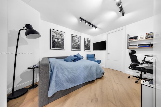 16001 Collins Ave Unit 707, Sunny Isles Beach, FL 33160 - bedroom featuring rail lighting, light wood-style flooring, and baseboards