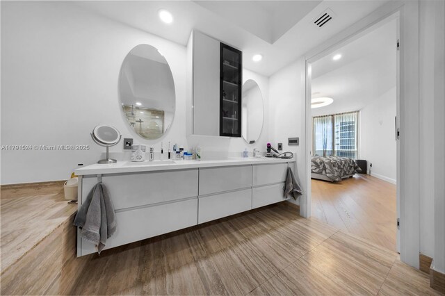16001 Collins Ave Unit 707, Sunny Isles Beach, FL 33160 - bathroom featuring double vanity, connected bathroom, recessed lighting, and wood finished floors