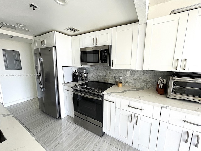kitchen with visible vents, a toaster, light stone counters, white cabinets, and stainless steel appliances