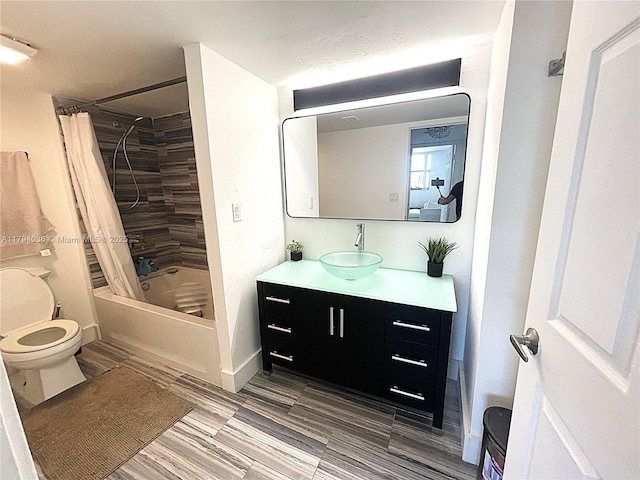 full bathroom with toilet, baseboards, shower / tub combo, and vanity