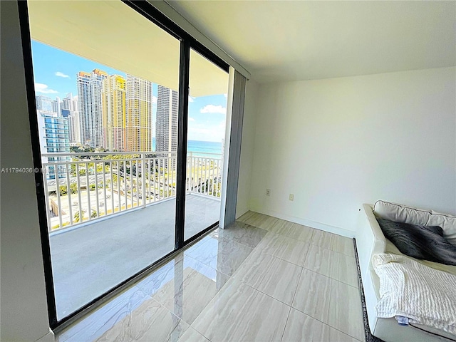 unfurnished bedroom featuring access to outside, a view of city, marble finish floor, and a water view
