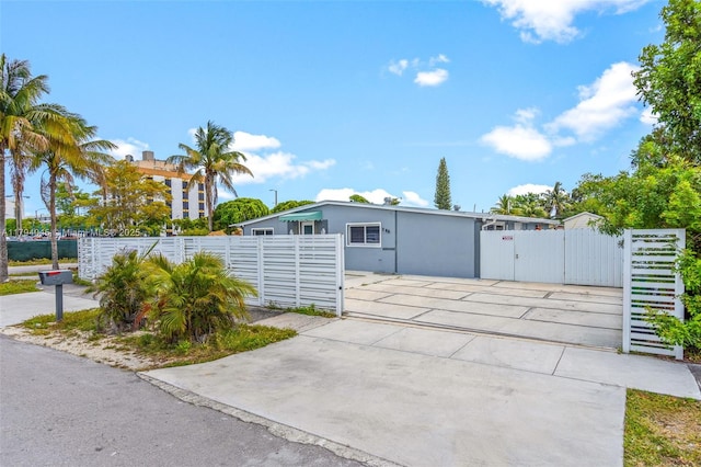 exterior space with concrete driveway, fence, and a gate