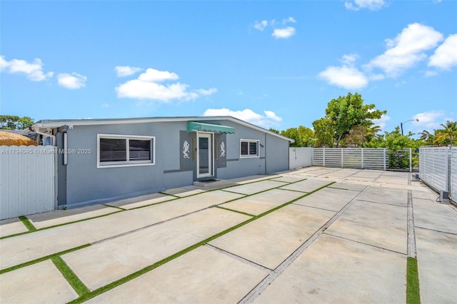 back of house featuring stucco siding, a gate, a patio area, and fence