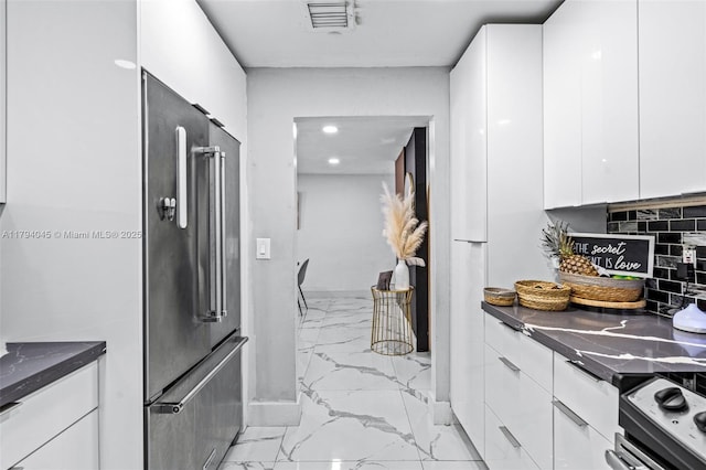 kitchen with visible vents, dark countertops, white cabinets, marble finish floor, and stainless steel appliances
