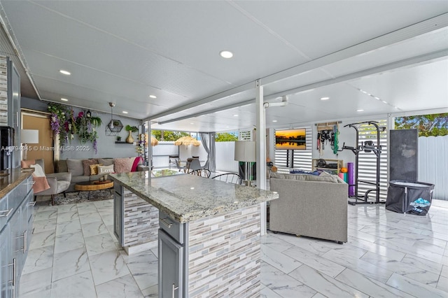 kitchen featuring recessed lighting, plenty of natural light, marble finish floor, and open floor plan