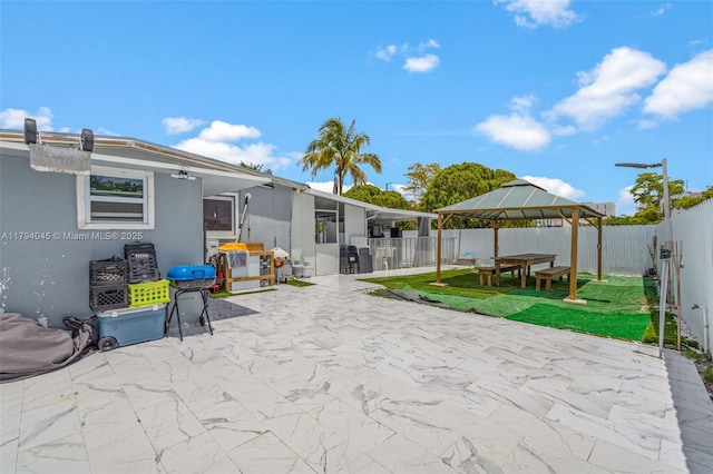 rear view of house with a gazebo, a fenced backyard, a patio, outdoor dining space, and stucco siding