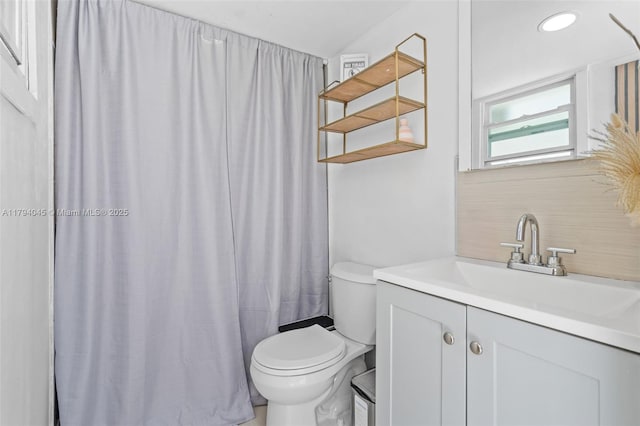 bathroom with vanity, decorative backsplash, curtained shower, and toilet