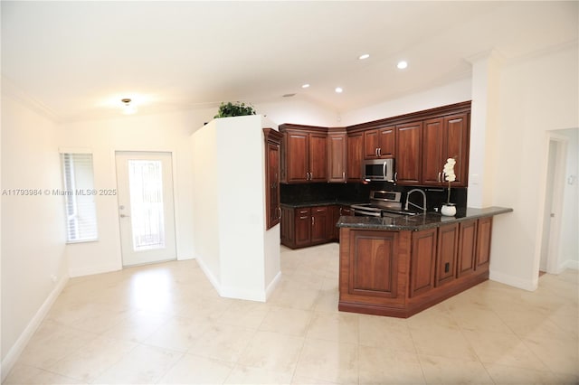 1583 Presidio Dr, Weston, FL 33327 - kitchen featuring appliances with stainless steel finishes, a peninsula, backsplash, dark stone counters, and baseboards