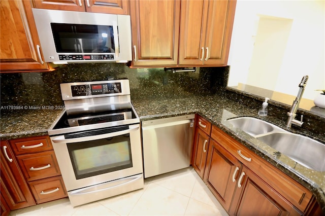 1583 Presidio Dr, Weston, FL 33327 - kitchen featuring stainless steel appliances, a sink, light tile patterned floors, tasteful backsplash, and dark stone countertops