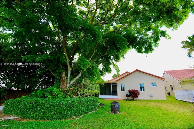 1583 Presidio Dr, Weston, FL 33327 - view of grassy yard featuring a sunroom and a fire pit