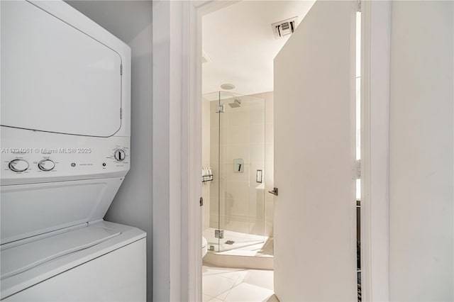 45 SW 9th St Unit 1204, Miami, FL 33130 - clothes washing area featuring visible vents, stacked washer and clothes dryer, tile patterned flooring, and laundry area