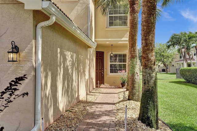 7643 Corkwood Ave, Boynton Beach, FL 33437 - view of exterior entry with stucco siding and a yard