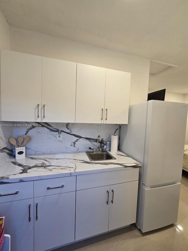 11015 SW 158th Ter, Miami, FL 33157 - kitchen featuring a sink, decorative backsplash, freestanding refrigerator, and white cabinetry
