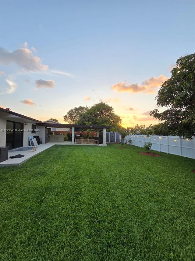 11015 SW 158th Ter, Miami, FL 33157 - yard at dusk featuring a fenced backyard, a patio area, and central AC unit