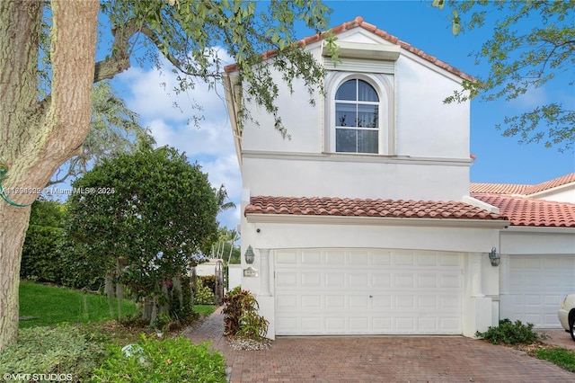 999 N Harbor Vw N, Hollywood, FL 33019 - mediterranean / spanish house featuring a garage, stucco siding, a tile roof, and decorative driveway