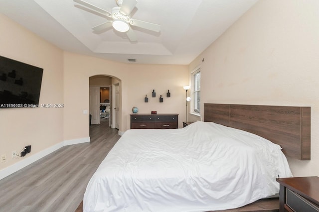 999 N Harbor Vw N, Hollywood, FL 33019 - bedroom featuring arched walkways, baseboards, wood finished floors, a tray ceiling, and visible vents