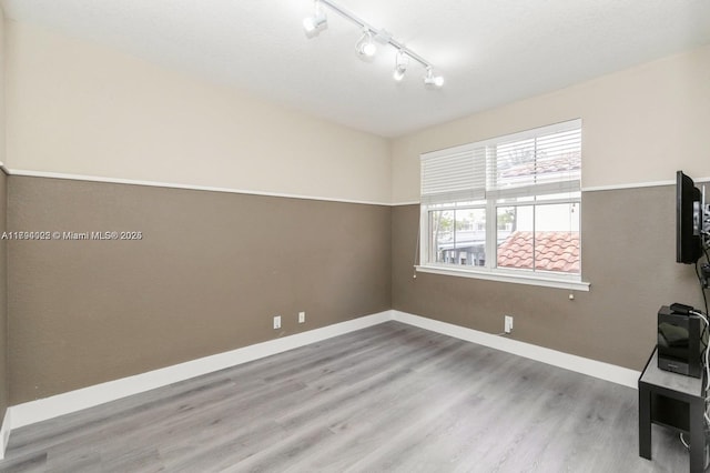 999 N Harbor Vw N, Hollywood, FL 33019 - spare room with baseboards, rail lighting, and wood finished floors