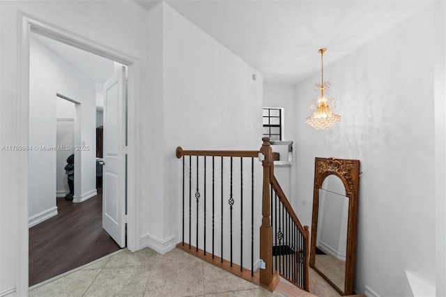 staircase with baseboards and a notable chandelier