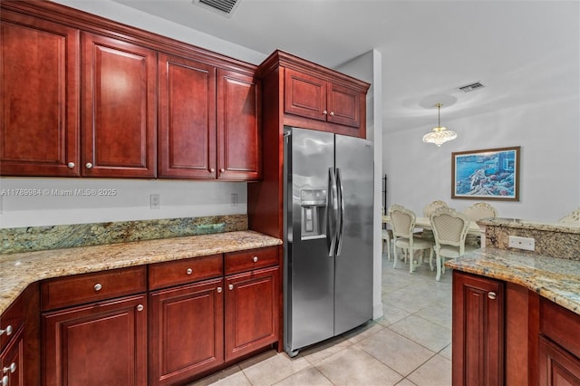 kitchen with stainless steel fridge, visible vents, light tile patterned flooring, and dark brown cabinets