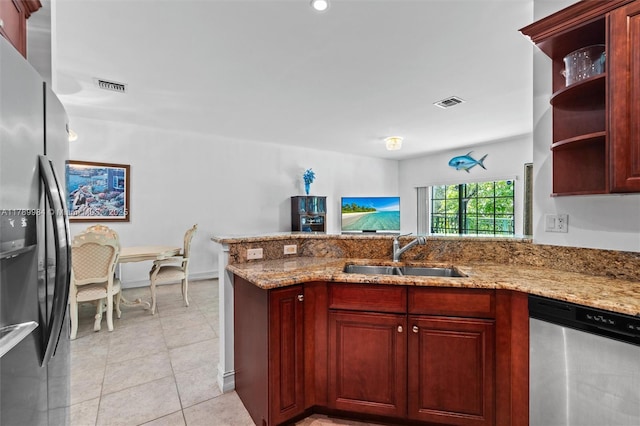 kitchen with dark brown cabinets, appliances with stainless steel finishes, a sink, and visible vents