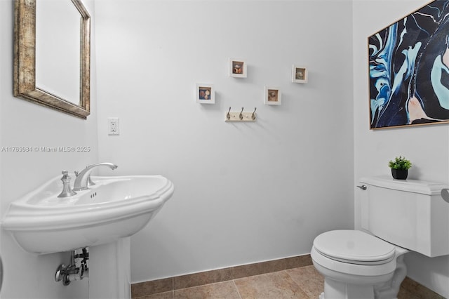 half bathroom featuring toilet and baseboards