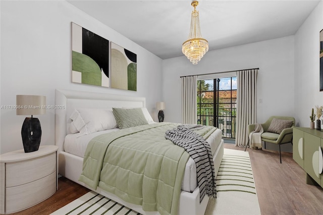 bedroom with wood finished floors, a chandelier, and access to exterior