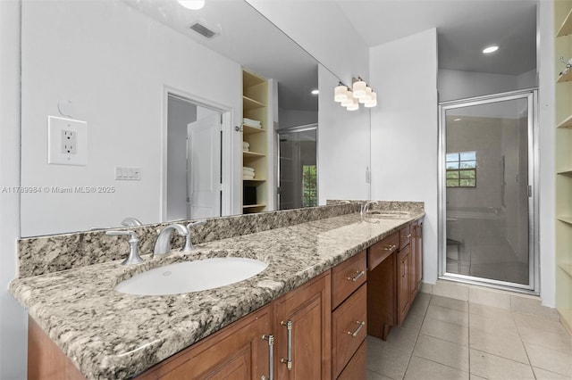 bathroom featuring double vanity, a sink, a stall shower, and visible vents