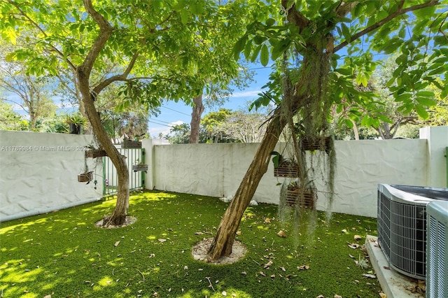 view of yard with central air condition unit and a fenced backyard