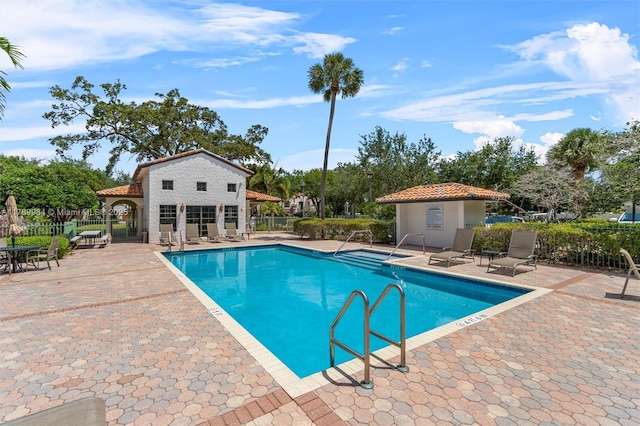 community pool featuring fence and a patio area