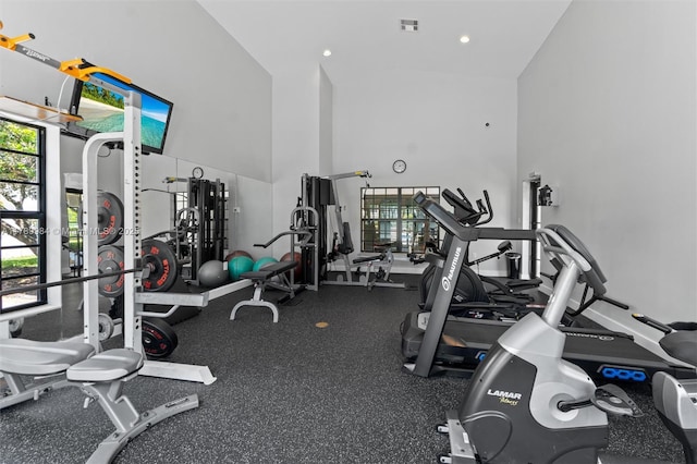 exercise room featuring visible vents, recessed lighting, and high vaulted ceiling